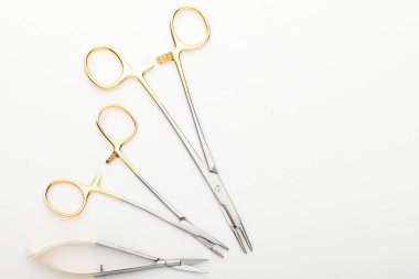 Çelik cerrahi aletler ve laboratuvar ekipmanları beyaz arka planda izole edilmiş. Profesyonel klinik aletleri. Tıbbi, cerrahi, ambulans ve veteriner konsepti. Yumuşak seçici odaklı yakın plan