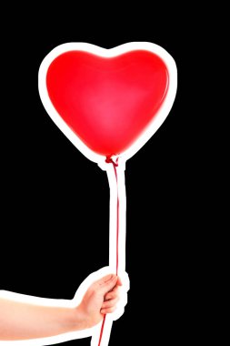 Kadın eli kırmızı kauçuk, şişme kalp şeklinde balon tutuyor. Aşk, ilişki, sevgililer günü ve doğum günü kutlaması konsepti. Boş kopya alanı olan dergi tarzı moda kolajı