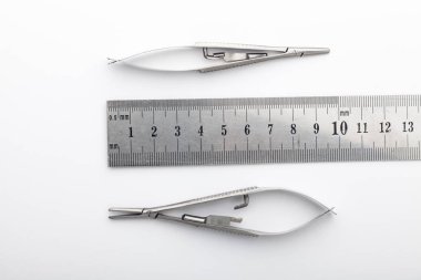 Çelik cerrahi aletler ve laboratuvar ekipmanları beyaz arka planda izole edilmiş. Profesyonel klinik aletleri. Tıbbi, cerrahi, ambulans ve veteriner konsepti. Yumuşak seçici odaklı yakın plan