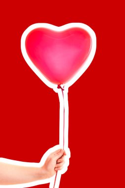 Kadın eli kırmızı kauçuk, şişme kalp şeklinde balon tutuyor. Aşk, ilişki, sevgililer günü ve doğum günü kutlaması konsepti. Boş kopya alanı olan dergi tarzı moda kolajı