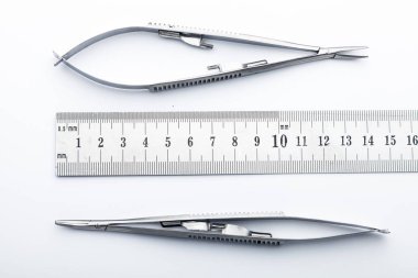 Çelik cerrahi aletler ve laboratuvar ekipmanları beyaz arka planda izole edilmiş. Profesyonel klinik aletleri. Tıbbi, cerrahi, ambulans ve veteriner konsepti. Yumuşak seçici odaklı yakın plan