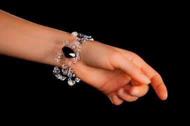 Güzel bir el yapımı mücevher bileziği. Renkli parlak boncuklar ve nötr manikürlü gevşek bir kadın bileği. Moda ve el işi aksesuarları. Yumuşak seçici odaklı yakın plan