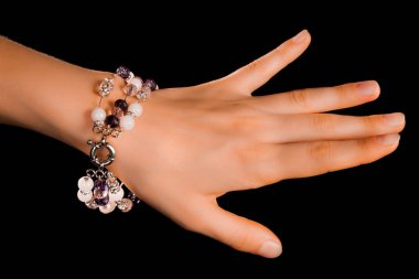 Güzel bir el yapımı mücevher bileziği. Renkli parlak boncuklar ve nötr manikürlü gevşek bir kadın bileği. Moda ve el işi aksesuarları. Yumuşak seçici odaklı yakın plan