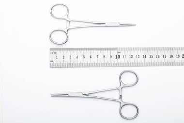 Çelik cerrahi aletler ve laboratuvar ekipmanları beyaz arka planda izole edilmiş. Profesyonel klinik aletleri. Tıbbi, cerrahi, ambulans ve veteriner konsepti. Yumuşak seçici odaklı yakın plan