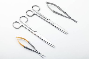 Çelik cerrahi aletler ve laboratuvar ekipmanları beyaz arka planda izole edilmiş. Profesyonel klinik aletleri. Tıbbi, cerrahi, ambulans ve veteriner konsepti. Yumuşak seçici odaklı yakın plan