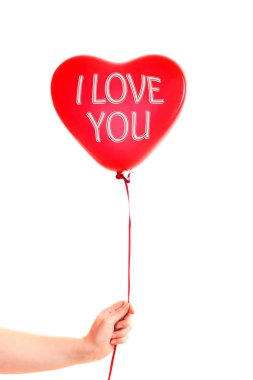 Kadın eli kırmızı kauçuk, şişme kalp şeklinde balon tutuyor. Aşk, ilişki, sevgililer günü ve doğum günü kutlaması konsepti. Stüdyo görüntüsü boş kopya alanı olan bulanık bir arkaplan üzerinde