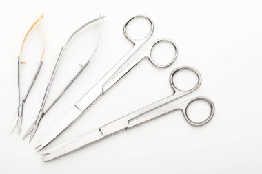 Çelik cerrahi aletler ve laboratuvar ekipmanları beyaz arka planda izole edilmiş. Profesyonel klinik aletleri. Tıbbi, cerrahi, ambulans ve veteriner konsepti. Yumuşak seçici odaklı yakın plan