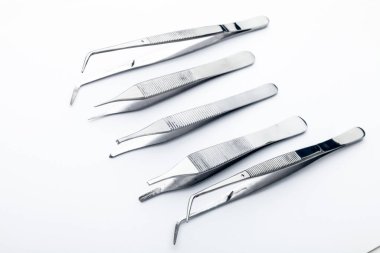 Çelik cerrahi aletler ve laboratuvar ekipmanları beyaz arka planda izole edilmiş. Profesyonel klinik aletleri. Tıbbi, cerrahi, ambulans ve veteriner konsepti. Yumuşak seçici odaklı yakın plan
