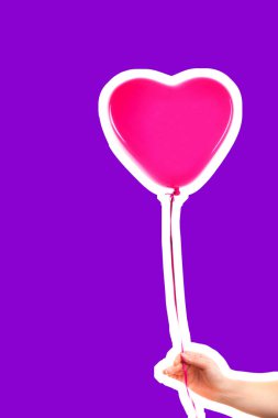 Kadın eli pembe kauçuk, şişme kalp şeklinde balon tutuyor. Aşk, ilişki, sevgililer günü ve doğum günü kutlaması konsepti. Boş kopya alanı olan dergi tarzı moda kolajı