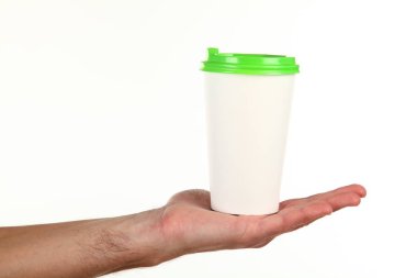 İnsan eli plastik kapaklı boş bir kahve fincanı tutar. Tek kullanımlık fincana çay ya da kahve konsepti. Metin veya logo için yeri ve yeri kopyala. Beyaz bir arkaplanda izole edilmiş