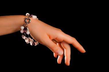 Güzel bir el yapımı mücevher bileziği. Renkli parlak boncuklar ve nötr manikürlü gevşek bir kadın bileği. Moda ve el işi aksesuarları. Yumuşak seçici odaklı yakın plan