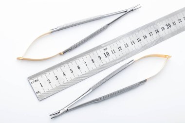 Çelik cerrahi aletler ve laboratuvar ekipmanları beyaz arka planda izole edilmiş. Profesyonel klinik aletleri. Tıbbi, cerrahi, ambulans ve veteriner konsepti. Yumuşak seçici odaklı yakın plan