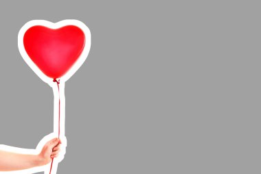 Kadın eli kırmızı kauçuk, şişme kalp şeklinde balon tutuyor. Aşk, ilişki, sevgililer günü ve doğum günü kutlaması konsepti. Boş kopya alanı olan dergi tarzı moda kolajı