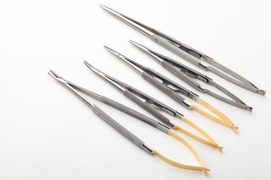 Çelik cerrahi aletler ve laboratuvar ekipmanları beyaz arka planda izole edilmiş. Profesyonel klinik aletleri. Tıbbi, cerrahi, ambulans ve veteriner konsepti. Yumuşak seçici odaklı yakın plan