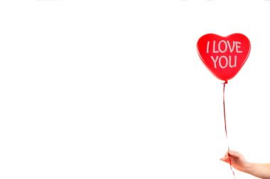 Kadın eli kırmızı kauçuk, şişme kalp şeklinde balon tutuyor. Aşk, ilişki, sevgililer günü ve doğum günü kutlaması konsepti. Stüdyo görüntüsü boş kopya alanı olan bulanık bir arkaplan üzerinde