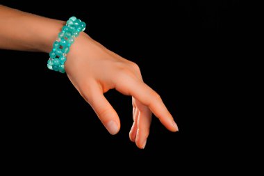 Güzel bir el yapımı mücevher bileziği. Renkli parlak boncuklar ve nötr manikürlü gevşek bir kadın bileği. Moda ve el işi aksesuarları. Yumuşak seçici odaklı yakın plan