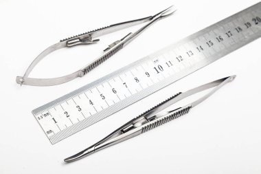 Çelik cerrahi aletler ve laboratuvar ekipmanları beyaz arka planda izole edilmiş. Profesyonel klinik aletleri. Tıbbi, cerrahi, ambulans ve veteriner konsepti. Yumuşak seçici odaklı yakın plan