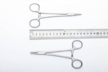 Çelik cerrahi aletler ve laboratuvar ekipmanları beyaz arka planda izole edilmiş. Profesyonel klinik aletleri. Tıbbi, cerrahi, ambulans ve veteriner konsepti. Yumuşak seçici odaklı yakın plan