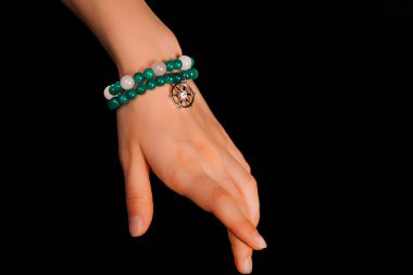 Güzel bir el yapımı mücevher bileziği. Renkli parlak boncuklar ve nötr manikürlü gevşek bir kadın bileği. Moda ve el işi aksesuarları. Yumuşak seçici odaklı yakın plan