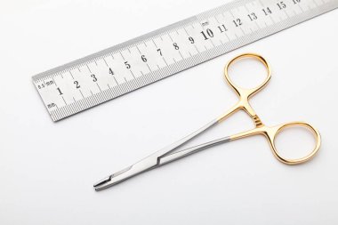 Çelik cerrahi aletler ve laboratuvar ekipmanları beyaz arka planda izole edilmiş. Profesyonel klinik aletleri. Tıbbi, cerrahi, ambulans ve veteriner konsepti. Yumuşak seçici odaklı yakın plan