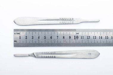 Çelik cerrahi aletler ve laboratuvar ekipmanları beyaz arka planda izole edilmiş. Profesyonel klinik aletleri. Tıbbi, cerrahi, ambulans ve veteriner konsepti. Yumuşak seçici odaklı yakın plan