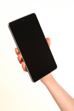 İnsan eli, avucunda boş bir krom ekran olan modern bir akıllı telefonu tutar. Teknoloji ve reklam kavramı. Ayrıntılı yakın çekim stüdyo çekimi soyut beyaz arka planda izole