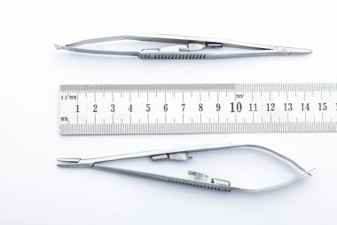 Çelik cerrahi aletler ve laboratuvar ekipmanları beyaz arka planda izole edilmiş. Profesyonel klinik aletleri. Tıbbi, cerrahi, ambulans ve veteriner konsepti. Yumuşak seçici odaklı yakın plan