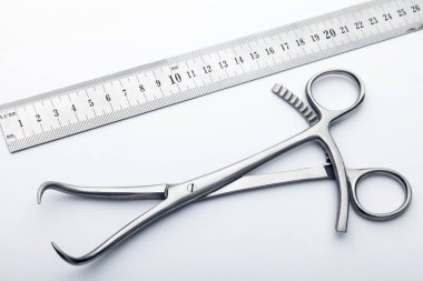 Çelik cerrahi aletler ve laboratuvar ekipmanları beyaz arka planda izole edilmiş. Profesyonel klinik aletleri. Tıbbi, cerrahi, ambulans ve veteriner konsepti. Yumuşak seçici odaklı yakın plan