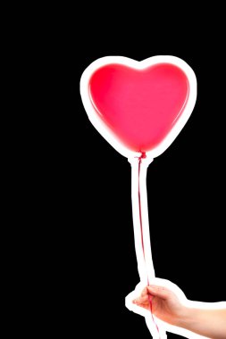 Kadın eli kırmızı kauçuk, şişme kalp şeklinde balon tutuyor. Aşk, ilişki, sevgililer günü ve doğum günü kutlaması konsepti. Boş kopya alanı olan dergi tarzı moda kolajı