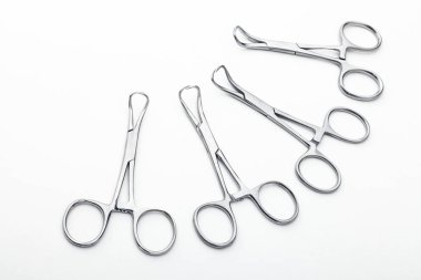 Çelik cerrahi aletler ve laboratuvar ekipmanları beyaz arka planda izole edilmiş. Profesyonel klinik aletleri. Tıbbi, cerrahi, ambulans ve veteriner konsepti. Yumuşak seçici odaklı yakın plan