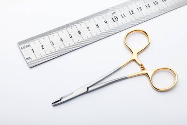 Çelik cerrahi aletler ve laboratuvar ekipmanları beyaz arka planda izole edilmiş. Profesyonel klinik aletleri. Tıbbi, cerrahi, ambulans ve veteriner konsepti. Yumuşak seçici odaklı yakın plan