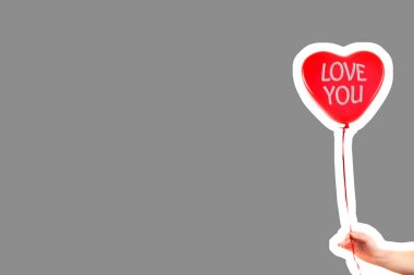 Kadın eli kırmızı kauçuk, şişme kalp şeklinde balon tutuyor. Aşk, ilişki, sevgililer günü ve doğum günü kutlaması konsepti. Boş kopya alanı olan dergi tarzı moda kolajı