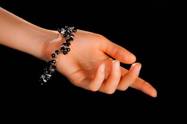 Güzel bir el yapımı mücevher bileziği. Renkli parlak boncuklar ve nötr manikürlü gevşek bir kadın bileği. Moda ve el işi aksesuarları. Yumuşak seçici odaklı yakın plan