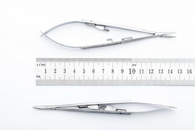 Çelik cerrahi aletler ve laboratuvar ekipmanları beyaz arka planda izole edilmiş. Profesyonel klinik aletleri. Tıbbi, cerrahi, ambulans ve veteriner konsepti. Yumuşak seçici odaklı yakın plan