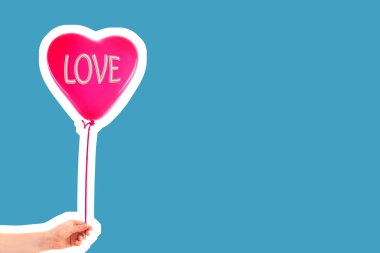 Kadın eli kırmızı kauçuk, şişme kalp şeklinde balon tutuyor. Aşk, ilişki, sevgililer günü ve doğum günü kutlaması konsepti. Boş kopya alanı olan dergi tarzı moda kolajı