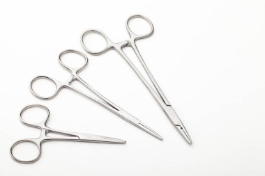 Çelik cerrahi aletler ve laboratuvar ekipmanları beyaz arka planda izole edilmiş. Profesyonel klinik aletleri. Tıbbi, cerrahi, ambulans ve veteriner konsepti. Yumuşak seçici odaklı yakın plan