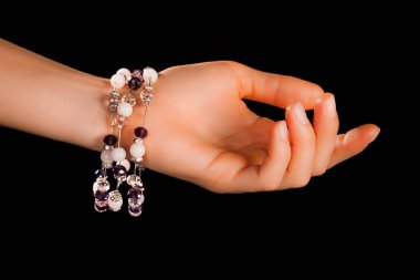 Güzel bir el yapımı mücevher bileziği. Renkli parlak boncuklar ve nötr manikürlü gevşek bir kadın bileği. Moda ve el işi aksesuarları. Yumuşak seçici odaklı yakın plan