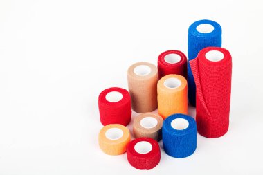 Esnek bandaj ve laboratuvar ekipmanları beyaz arka planda izole edilmiş. Profesyonel klinik aletleri. Tıbbi, cerrahi, ambulans ve veteriner konsepti. Yumuşak seçici odaklı yakın plan