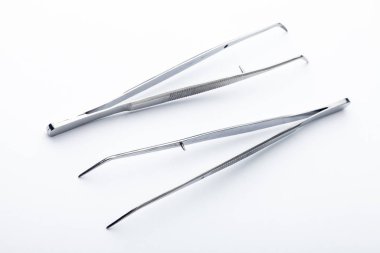 Çelik cerrahi aletler ve laboratuvar ekipmanları beyaz arka planda izole edilmiş. Profesyonel klinik aletleri. Tıbbi, cerrahi, ambulans ve veteriner konsepti. Yumuşak seçici odaklı yakın plan