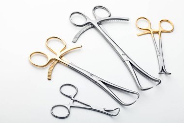 Çelik cerrahi aletler ve laboratuvar ekipmanları beyaz arka planda izole edilmiş. Profesyonel klinik aletleri. Tıbbi, cerrahi, ambulans ve veteriner konsepti. Yumuşak seçici odaklı yakın plan