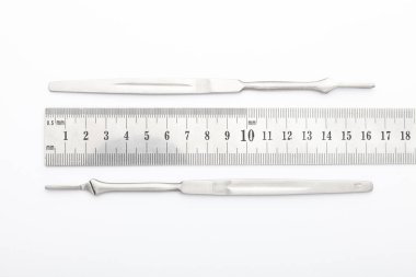 Çelik cerrahi aletler ve laboratuvar ekipmanları beyaz arka planda izole edilmiş. Profesyonel klinik aletleri. Tıbbi, cerrahi, ambulans ve veteriner konsepti. Yumuşak seçici odaklı yakın plan