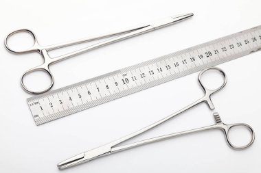 Çelik cerrahi aletler ve laboratuvar ekipmanları beyaz arka planda izole edilmiş. Profesyonel klinik aletleri. Tıbbi, cerrahi, ambulans ve veteriner konsepti. Yumuşak seçici odaklı yakın plan