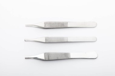 Çelik cerrahi aletler ve laboratuvar ekipmanları beyaz arka planda izole edilmiş. Profesyonel klinik aletleri. Tıbbi, cerrahi, ambulans ve veteriner konsepti. Yumuşak seçici odaklı yakın plan