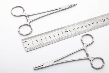 Çelik cerrahi aletler ve laboratuvar ekipmanları beyaz arka planda izole edilmiş. Profesyonel klinik aletleri. Tıbbi, cerrahi, ambulans ve veteriner konsepti. Yumuşak seçici odaklı yakın plan