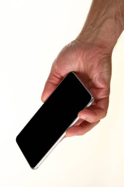 İnsan eli, avucunda boş bir krom ekran olan modern bir akıllı telefonu tutar. Teknoloji ve reklam kavramı. Ayrıntılı yakın çekim stüdyo çekimi soyut beyaz arka planda izole