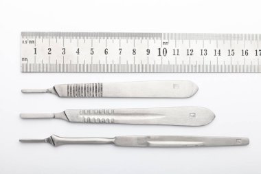 Çelik cerrahi aletler ve laboratuvar ekipmanları beyaz arka planda izole edilmiş. Profesyonel klinik aletleri. Tıbbi, cerrahi, ambulans ve veteriner konsepti. Yumuşak seçici odaklı yakın plan