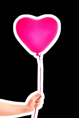 Kadın eli pembe kauçuk, şişme kalp şeklinde balon tutuyor. Aşk, ilişki, sevgililer günü ve doğum günü kutlaması konsepti. Boş kopya alanı olan dergi tarzı moda kolajı