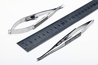 Çelik cerrahi aletler ve laboratuvar ekipmanları beyaz arka planda izole edilmiş. Profesyonel klinik aletleri. Tıbbi, cerrahi, ambulans ve veteriner konsepti. Yumuşak seçici odaklı yakın plan