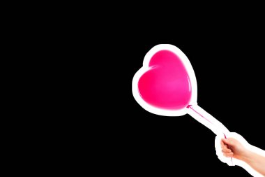 Kadın eli pembe kauçuk, şişme kalp şeklinde balon tutuyor. Aşk, ilişki, sevgililer günü ve doğum günü kutlaması konsepti. Boş kopya alanı olan dergi tarzı moda kolajı