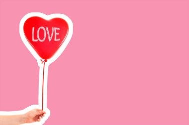 Kadın eli kırmızı kauçuk, şişme kalp şeklinde balon tutuyor. Aşk, ilişki, sevgililer günü ve doğum günü kutlaması konsepti. Boş kopya alanı olan dergi tarzı moda kolajı
